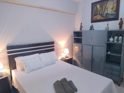 a bedroom with a white bed with two towels on it at S&B Apartamento in Asuncion