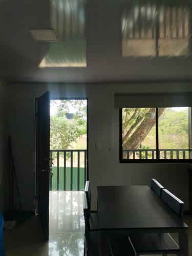 a dining room with a table and a balcony at Bee in Veintisiete de Abril