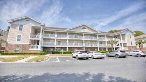 a large apartment building with cars parked in a parking lot at 421 Cypress Bend condo in North Myrtle Beach