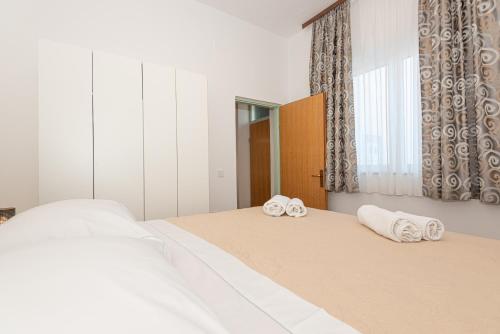 a bedroom with two beds with towels on them at Apartments Lovrić in Vodice