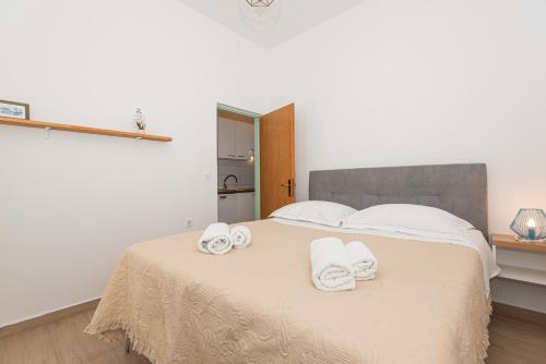 a bedroom with a bed with towels on it at Apartments Lovrić in Vodice