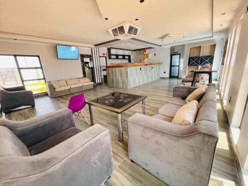 una gran sala de estar con sofás y una mesa. en Shafas Guest House, en Rundu