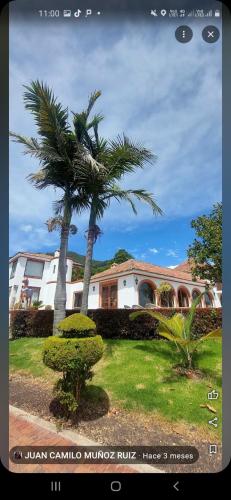 una foto de una casa con una palmera en Hotel Juaica, en Tenjo