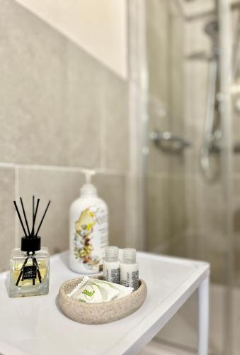 a white table with bottles of soap and a shower at Residence Internazionale in Pietrasanta