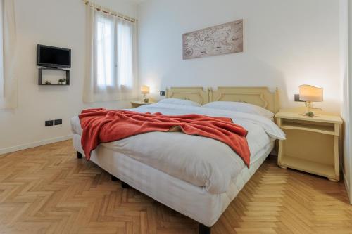 a bedroom with a bed with a red blanket on it at Villa Luccon - Mirano Centro Storico in Mirano