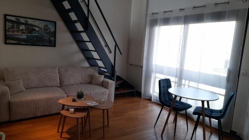 a living room with a couch and a table at triplex, centre-ville, terrasse in Nogent-sur-Marne