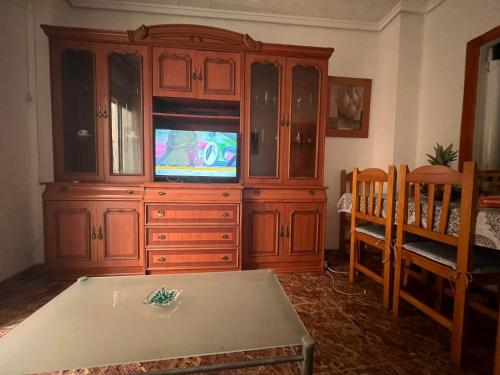 a large wooden entertainment center with a television in it at Habitación cerca a la playa. in Valencia
