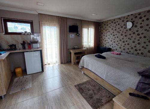 ein Schlafzimmer mit einem Bett und einer Küche darin in der Unterkunft Guesthouse Saba in Bordschomi