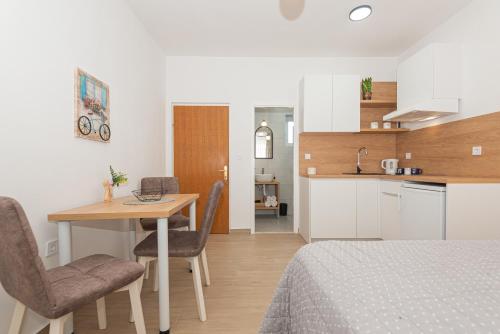 a room with a bed and a table and a kitchen at Apartments Lovrić in Vodice