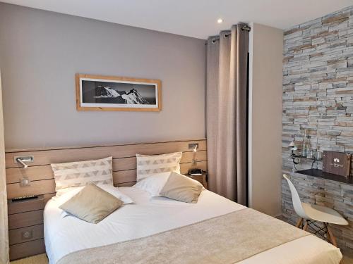 a bedroom with a large white bed in a room at Hôtel des Princes, Chambéry Centre in Chambéry
