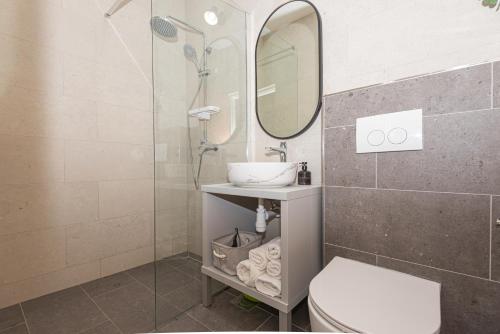 a bathroom with a shower and a toilet and a sink at Apartments Lovrić in Vodice