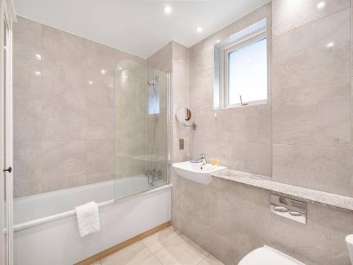 ein Badezimmer mit einer Badewanne, einem Waschbecken und einem Badetubermott in der Unterkunft Pass the Keys Spacious Apartment in Camberwell in London