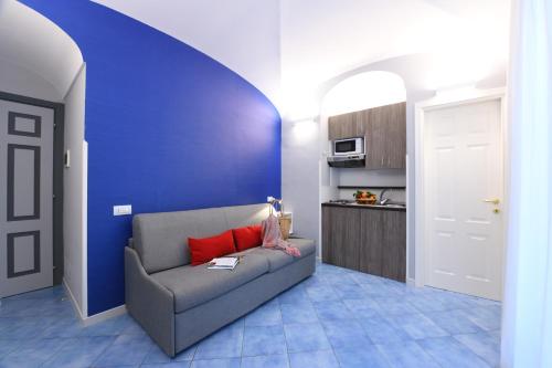 a living room with a couch and a blue wall at Casa Amalfi centro storico in Amalfi