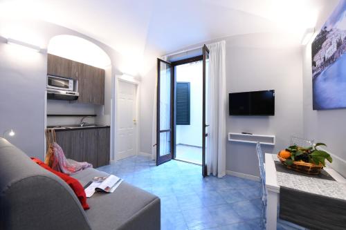 a living room with a couch and a television at Casa Amalfi centro storico in Amalfi