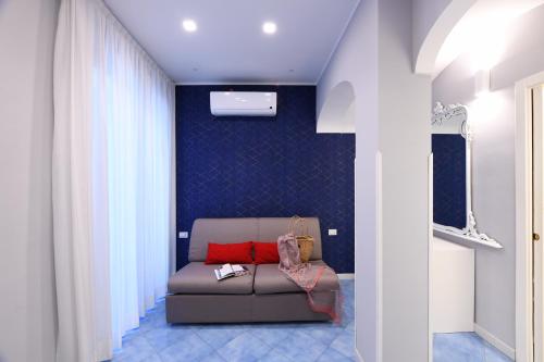 a living room with a couch and a blue wall at Casa Amalfi centro storico in Amalfi