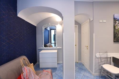 La salle de bains est pourvue de murs bleus et d'un miroir. dans l'établissement La Casa ad Amalfi centro storico, à Amalfi