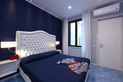 a bedroom with a blue bed with a white headboard at Casa Amalfi centro storico in Amalfi