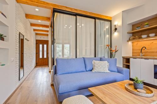 Una sala de estar con un sofá azul y una mesa. en Lola Apartments, en Liapades