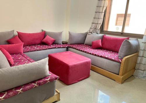 ein Wohnzimmer mit einem Sofa und rosa Kissen in der Unterkunft Atla's Ruby in Marrakesch