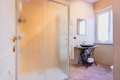 a glass shower door in a bathroom with a table at Campagna Cremasca-A/C-Wi Fi-Tasting vini top all in Crema