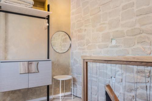 a room with a stone wall and a table and stool at L&B amphitheater apartments in Pula