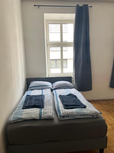 łóżko z dwoma poduszkami przed oknem w obiekcie 8-9Sam Apartment vienna w Wiedniu