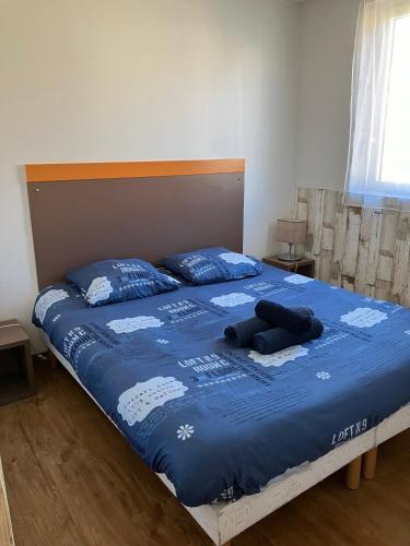 - un lit avec une couverture bleue et des oreillers dans l'établissement 2 pièces avec piscine, 150 m de la plage., à Cannes