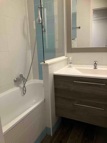 La salle de bains est pourvue d'un lavabo, d'une baignoire, d'un lavabo et d'un miroir. dans l'établissement 2 pièces avec piscine, 150 m de la plage., à Cannes