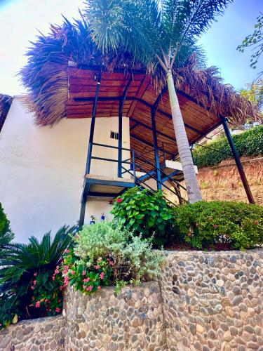 a house with a staircase and a palm tree at Tayrona Angel Lodge in El Zaino