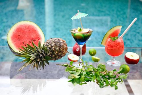 a table with two cocktails and fruit on it at The Autograph Inn in Siliguri
