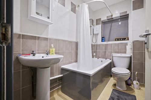W łazience znajduje się umywalka, toaleta i prysznic. w obiekcie Stunning 5 bedroom home Long stays contactors welcome w Birmingham