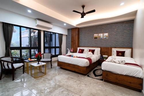 a bedroom with two beds and a ceiling fan at The Autograph Inn in Siliguri