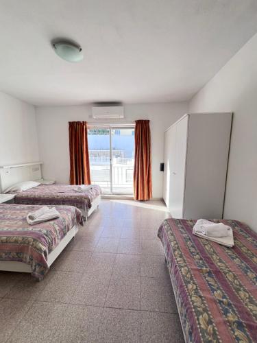 a hotel room with two beds and a window at Garden View Apartment No 40 in Tal-Franċiż