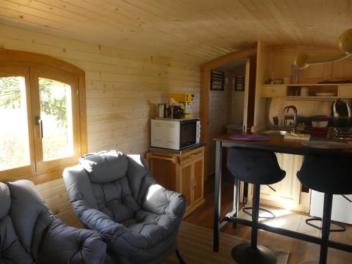 a living room with a couch and a table in a cabin at Roulotte quatre saisons Chez Sophie et Gilles in Monistrol-sur-Loire