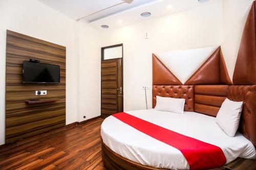 a bedroom with a large bed and a tv at Woodcrust Lodge in Udaipur