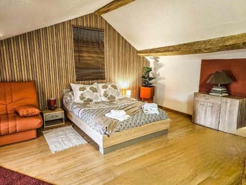 - une chambre avec un lit et une chaise dans l'établissement maison de ville avec jardin privatif, à Nevers