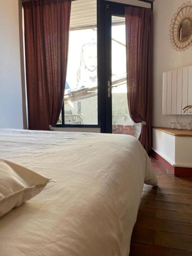 une chambre avec un grand lit et une fenêtre dans l'établissement Authentique & agréable maison, à Auch