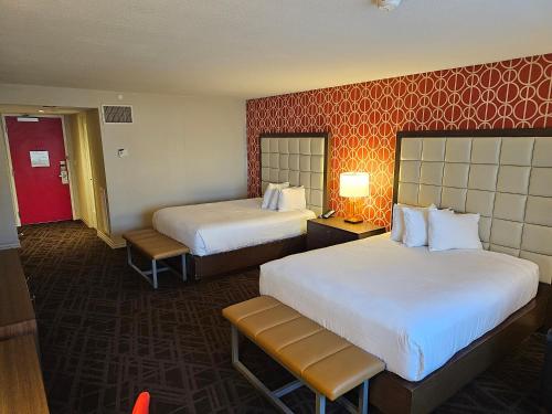 a hotel room with two beds and a red wall at Perfect Spot Unit by Horseshoe Casino Strip Las Vegas in Las Vegas