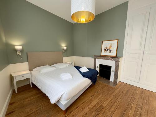 een slaapkamer met een wit bed en een open haard bij Appartement Le Corneille centre ville climatisé in Saumur