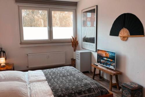 een slaapkamer met een bed en een televisie. bij Retro & Vintage Apartment in Erkrath