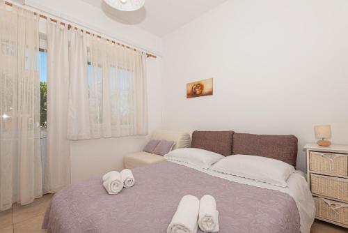 a bedroom with a bed with white towels on it at Apartments Lovrić in Vodice