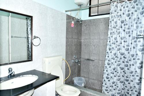 a bathroom with a sink and a toilet and a shower at SAS Apartment in Bangalore
