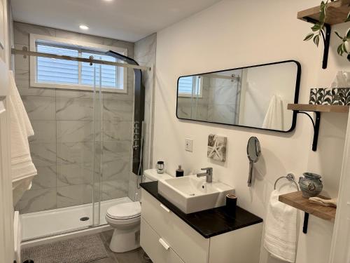 a white bathroom with a sink and a shower at Coin paisible au large de Québec in Quebec City