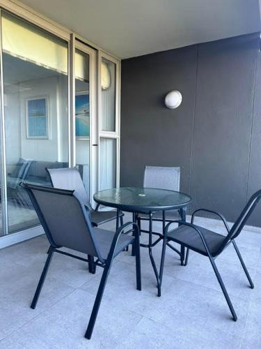 a glass table and chairs in a room at Ocean Dunes Bachelor Apartments in Umhlanga