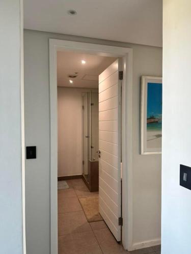an empty hallway with a hallway leading to a room at Ocean Dunes Bachelor Apartments in Umhlanga