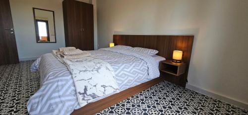 a bedroom with a large white bed with two lamps at ΣΟΧΟΣ ΠΑΡΑΔΟΣΙΑΚΕΣ ΟΙΚΙΕΣ - Πουλάτα in Zokhós