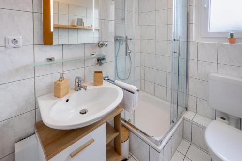 een badkamer met een wastafel en een douche bij MINT Design-Studio mit Balkon in Dortmund