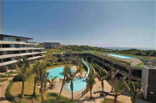 an aerial view of a resort with a pool and palm trees at Ocean Dunes Bachelor Apartments in Umhlanga