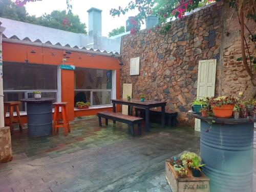 eine Terrasse mit einem Tisch und einer Steinmauer in der Unterkunft Palta Hostel in Montevideo