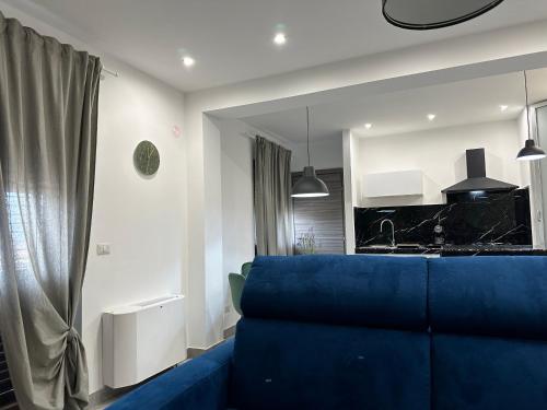 a living room with a blue couch and a kitchen at Amour Içi Boutique Apartments in centro in Mascalucia
